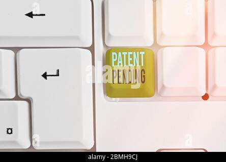 Writing note showing Patent Pending. Business concept for Request already filed but not yet granted Pursuing protection Stock Photo