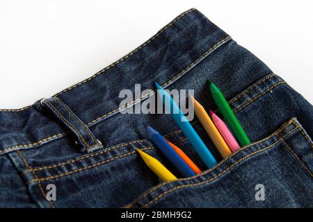 Color pencils stick out in blue jeans pocket on a white background Stock Photo