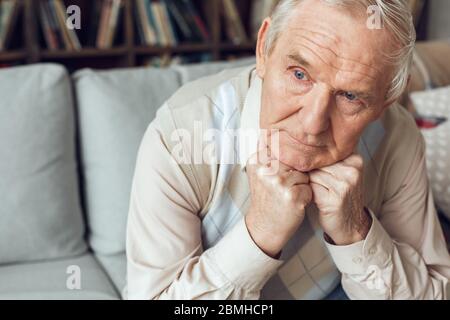 Senior man alone sitting at library looking out the window curious Stock Photo