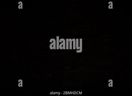 Dark, almost black, old red brick wall. Full frame textured background. Copy space. Stock Photo