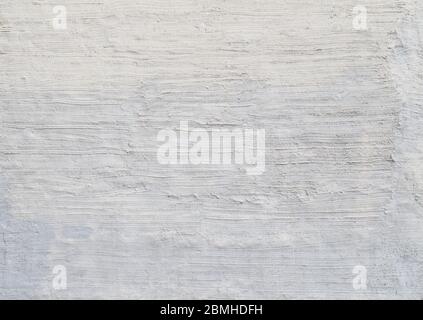 Plastered and rough concrete or stone wall painted in white or light gray, hand made stucco texture. High resolution full frame textured background. Stock Photo