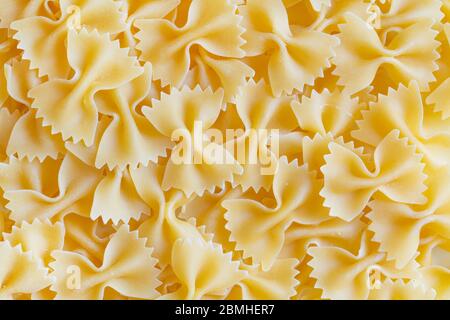 High-quality farfalle pasta background. Raw organic farfalle. Traditional Italian farfalle pasta. Italian Cuisine. Bow tie noodles. Uncooked dried Stock Photo