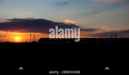 Virgin Trains / Avanti west coast Bombardier diesel voyager  train making a sunset silhouette on the electrified west coast mainline