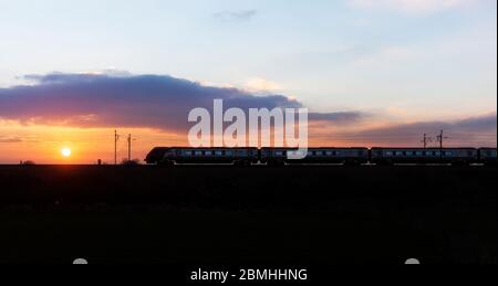 Virgin Trains / Avanti west coast Bombardier diesel voyager  train making a sunset silhouette on the electrified west coast mainline
