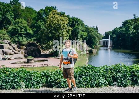 Sofia Park, Ukraine. Handsome man with a beard in a dendrological park. A man walks in a picturesque park with a lake. Stock Photo