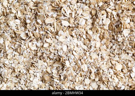 Oatmeal texture background. Fresh whole grain oats. Close up of cereal grain. Healthy food concept. Dry oats. Muesli for breakfast. Top view. Stock Photo