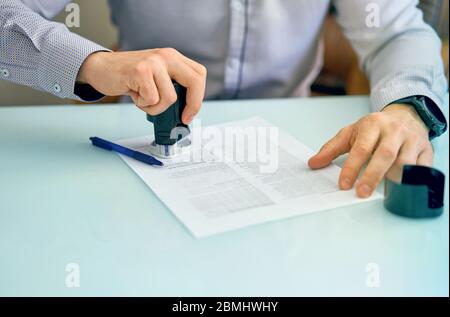 the man puts a seal on the document Stock Photo