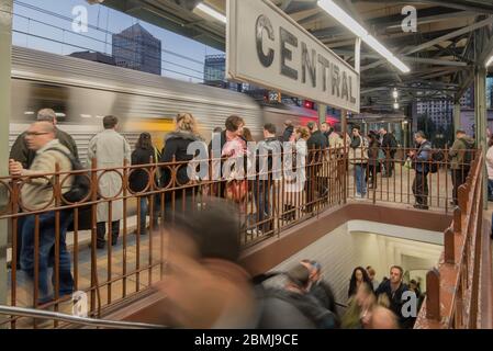 Crowds of people wait to board an incoming commuter train on a winters evening at Sydney's Central Station in New South Wales, Australia Stock Photo