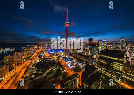 Toronto, Ontario, Canada, panoramic view of Toronto cityscape including architectural landmark CN Tower illuminated at night.