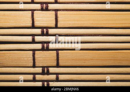 Bamboo mat background close up. wooden backdrop. wooden sticks bound together Stock Photo