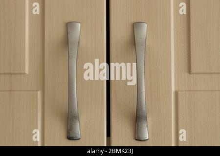 Cabinet handles close-up. Cabinet color is white and handle color is gray. Stock Photo