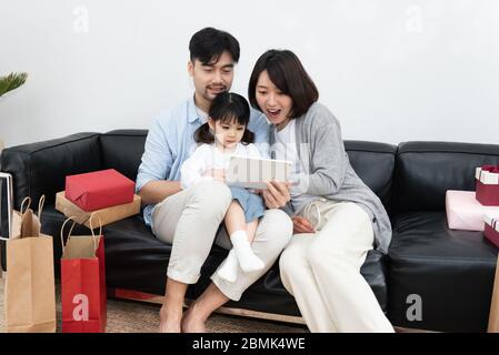 Young Asian mom and dad are unpacking gifts with their daughter Stock Photo  - Alamy