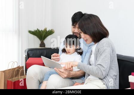 Young Asian mom and dad are unpacking gifts with their daughter Stock Photo