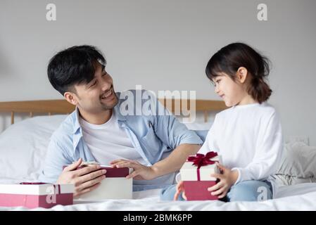 Young Asian mom and dad are unpacking gifts with their daughter Stock Photo  - Alamy