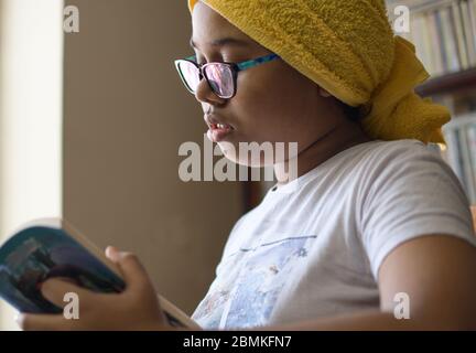 Little Indian girl studies at home maintaining social distance during lock down period for Covid-19.