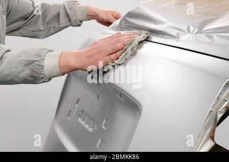 Auto mechanic preparing the car for paint job in painting booth in auto repair shop Stock Photo