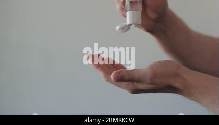 man apply sanitizer gel to his hands closeup Stock Photo