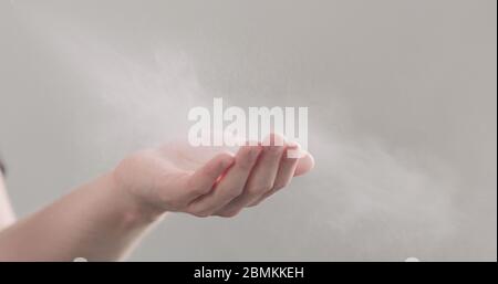 man spraying sanitizer on his hands side shot Stock Photo