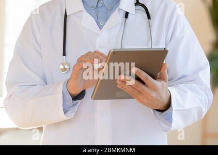 Male doctor make notes using tablet gadget Stock Photo