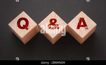 Q and A on wooden blocks Close-up Shot . Question and answers support center business concept Stock Photo