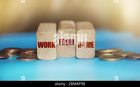 WORK FROM HOME on wooden block and coins around. Freelance home business concept Stock Photo