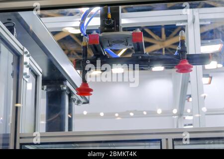 Close up view of automatic pick and place robotic arm manipulator with suction cups - part of plastic injection molding machine at exhibition, trade Stock Photo