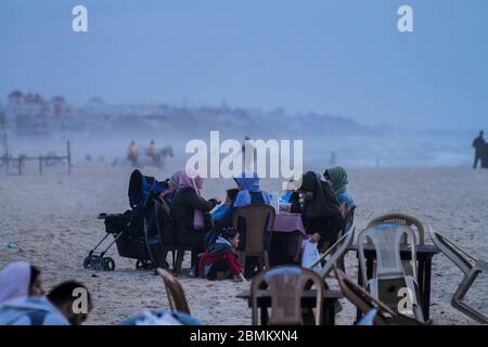 Gaza, Palestine. 09th May, 2020. Palestinians break their fast and have their iftar dinner on the shore of Gaza during the muslim holy month of Ramadan. Iftar is the evening meal consumed by families at the end the daily Ramadan fast. During this year's Ramadan Gazans are having to face the Covid-19 threat in addition to the usual power outages and economic crisis. Credit: ZUMA Press, Inc./Alamy Live News Stock Photo