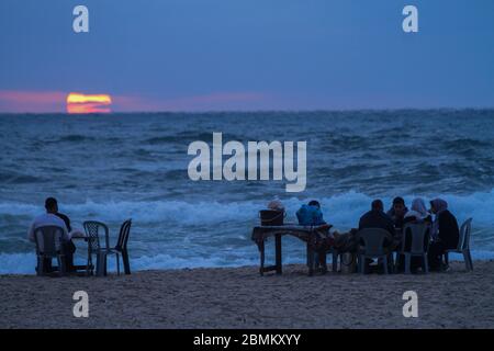 Gaza, Palestine. 09th May, 2020. Palestinians break their fast and have their iftar dinner on the shore of Gaza during the muslim holy month of Ramadan. Iftar is the evening meal consumed by families at the end the daily Ramadan fast. During this year's Ramadan Gazans are having to face the Covid-19 threat in addition to the usual power outages and economic crisis. Credit: ZUMA Press, Inc./Alamy Live News Stock Photo