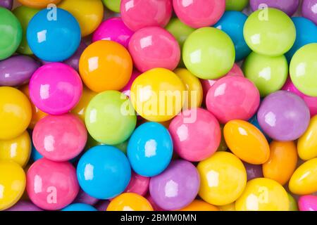 Pile of colorful sweet candy chocolates coated on white paper. colourful collection background Stock Photo