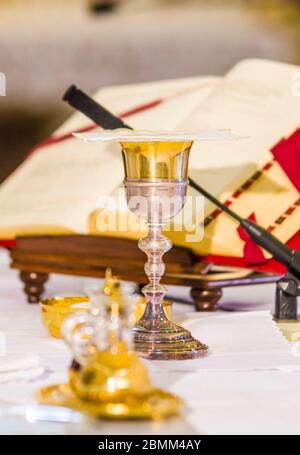 altar with host that becomes the body of jesus christ and chalice for wine, blood of christ, with the book for the mass of the faithful Stock Photo