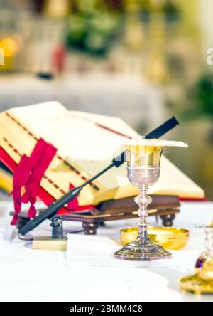 altar with host that becomes the body of jesus christ and chalice for wine, blood of christ, with the book for the mass of the faithful Stock Photo