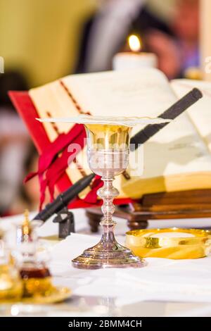 altar with host that becomes the body of jesus christ and chalice for wine, blood of christ, with the book for the mass of the faithful Stock Photo