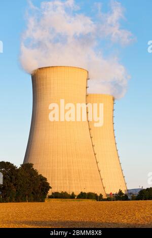 Two tall cooling towers of a nuclear power station with blue sky and a field. Stock Photo