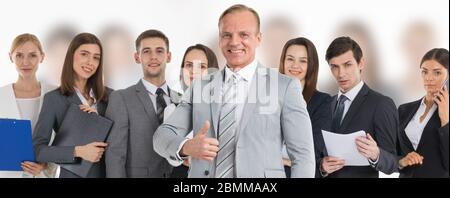 Business man hold hand with thumb up gesture, business man excited happy smile over group of businesspeople team background Stock Photo