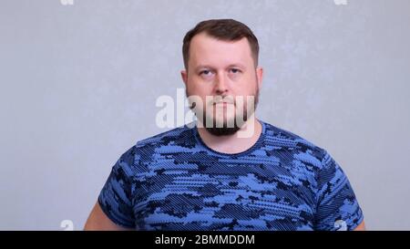 Portrait of a tired fat bearded man in a blue t-shirt Stock Photo