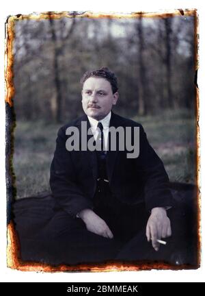 Portrait d'homme, riche pere de famille parisien, posant une cigarette a la main, il est assis dans un jardin en costume - 1920 environ (Portrait of a Stock Photo