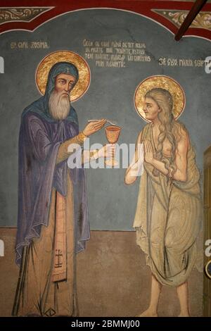 St. Zosimas giving the Holy Communion to St. Mary of Egypt -- fresco on the interior of an Orthodox church in  Romania Stock Photo