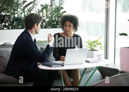 Multiracial colleagues talking share ideas working together on common task Stock Photo