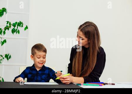 mother and young son draws a picture at the table Stock Photo
