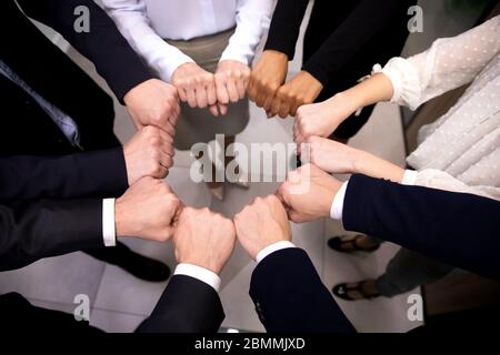 Closeup view businesspeople standing in circle fists bumping showing unity Stock Photo