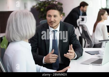 Colleagues discussing task working on new project in coworking office Stock Photo