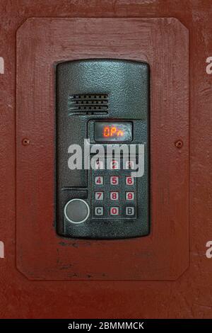 an intercom on old painted brown steel surface with a keypad, digital display and rfid sensor for calling close-up Stock Photo