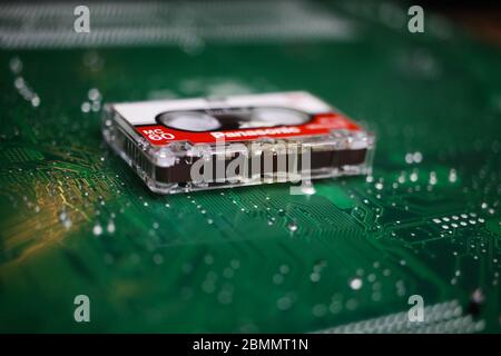 Viersen, Germany - May 9. 2020: Isolated old recorder tape on green computer circuit board (focus on tape) Stock Photo