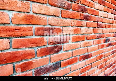 Old weathered red brick wall as background. Bricks masonry with seams. View from the angle Stock Photo