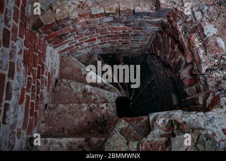 Old spiral staircase inside red brick tower, upside view Stock Photo