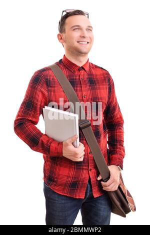 Portrait of a smiling young man in stylish plaid shirt with a shoulder bag holding a notebook, isolated on white background. Stock Photo