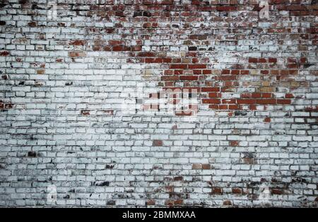 Old weathered vintage brick wall partialy painted white Stock Photo
