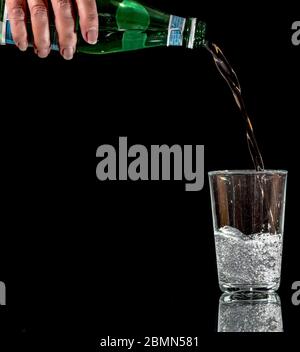 Pouring sparkling mineral water into a glass. Stock Photo