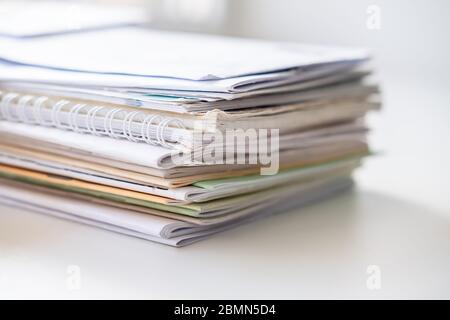 Pile of different notebooks on a white windowsill, in natural light from the window. Stock Photo