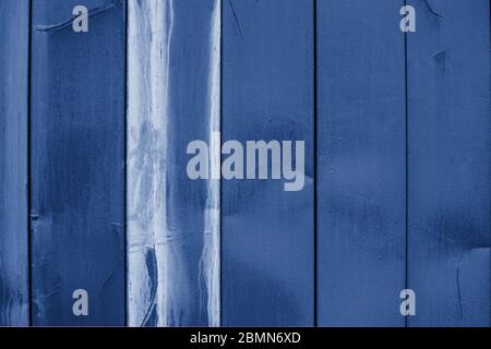 Vertical siding classic blue color, old wall cladding surface with smudges of white paint, textured effect. Background wallpaper backdrop texture for Stock Photo